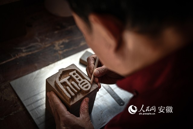 老师傅在陶泥上雕刻“福”字。人民网记者 苗子健摄